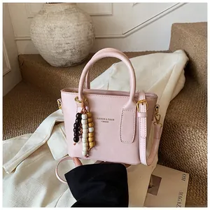 Detailansicht der rosa PU-Leder Eimertasche mit Holzperlen und goldenen Metallteilen