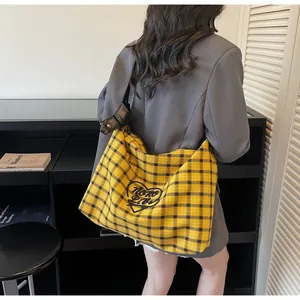 Detail of a large yellow plaid canvas tote bag with heart embroidery for women