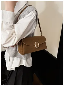 Detailed close-up of brown suede shoulder bag featuring a vintage gold rectangular buckle