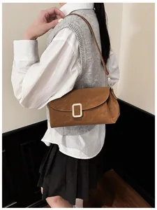 Close-up of a retro brown faux suede shoulder bag featuring a metallic square magnetic buckle