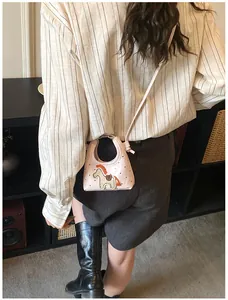 Dettaglio della mini borsa rosa con stampa a cuori, ricamo pony e tracolla sottile