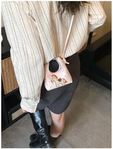 Dettaglio della mini borsa rosa con stampe di cuori e patch a forma di cavallo in maglia