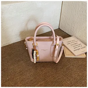 Detailansicht der rosa Beuteltasche mit Perlenanhänger und verstellbarem Schultergurt