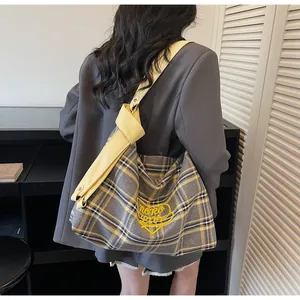 Detail of yellow and grey plaid canvas tote bag featuring a yellow heart embroidery