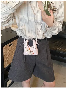 Dettaglio mini borsa rosa con toppa a cavallino e pois indossata da una modella