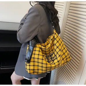 Close-up of large plaid tote bag featuring yellow check pattern and black embroidery