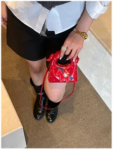 Dettaglio di una mini borsa rossa a pois bianchi con ricamo di un cavallo blu