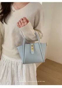 Hellblaue Eimertasche mit Lychee-Muster, goldenem Drehverschluss und elegantem Griff