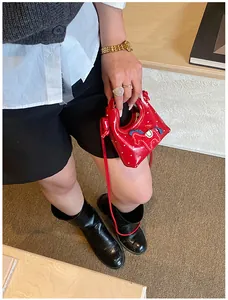 Dettaglio mini borsa rossa con ricamo a forma di pony e piccoli pois bianchi