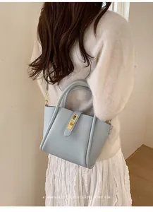 Detailansicht hellblaue Lederhandtasche mit Litschimuster und goldenem Drehverschluss