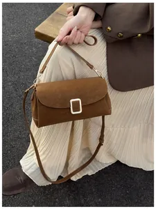 Detail of caramel suede square bag with silver buckle and adjustable shoulder strap