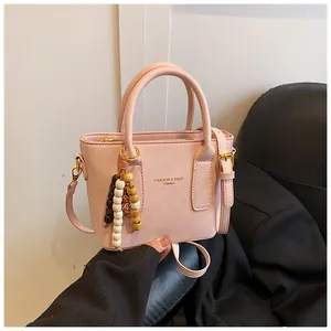Detail der hellrosa PU-Leder Beuteltasche mit Griffen und Quastenanhänger-Verzierung