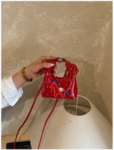 Dettaglio mini borsa rossa con cuori stampati e toppa a forma di pony per bambini