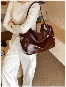 Dunkelbraune glänzende Oversize-Tasche am Model für einen trendigen Urban-Look