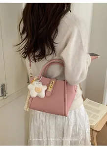 Detailansicht der rosa Beuteltasche mit Litschi-Muster, Sternanhänger und Schloss