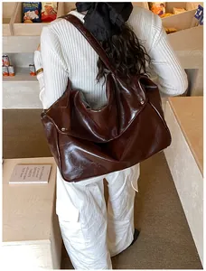 Nahaufnahme der braunen Vintage-Schultertasche aus glänzendem Öl-Wachs-Leder mit Nieten