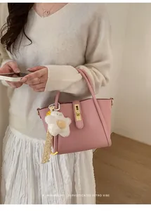 Rosafarbene Eimertasche mit Sternanhänger, getragen als Umhängetasche am Model