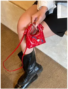 Dettaglio della mini borsa rossa con stampe bianche e patch pony blu sulle scale