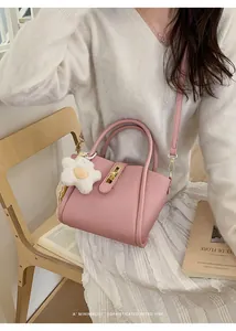 Nahaufnahme der rosa Handtasche mit Litschiprägung, Metallschnalle und Anhänger