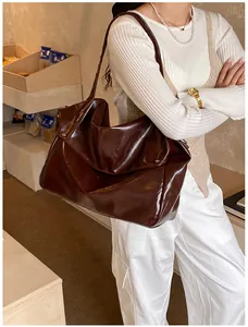 Detail einer großen schokobraunen Lackledertasche mit glänzendem Finish für Damen
