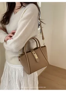 Detailansicht der khakifarbenen Beuteltasche mit Litschi-Struktur und goldenem Drehverschluss