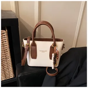 Detail der Kontrastfarbenen Beuteltasche mit Perlenanhänger und glattem Leder-Finish