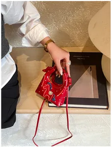 Dettaglio della mini borsa rossa con pois bianchi e ricamo pony su pelle lucida
