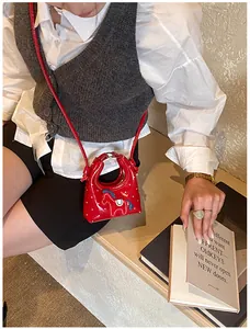 Dettaglio della mini borsa rossa con ricamo di cavallo e pois bianchi eleganti