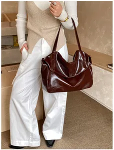 Detailansicht der dunkelbraunen, glänzenden Leder-Schultertasche mit weichem Falten-Design