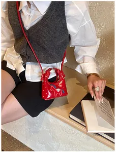 Dettaglio di una mini borsa rossa a pois bianchi con motivo a cavallo ricamato