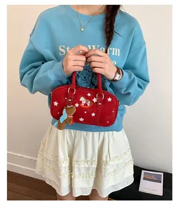 Detail of red Boston bag featuring star prints, horse embroidery and plush dog charm