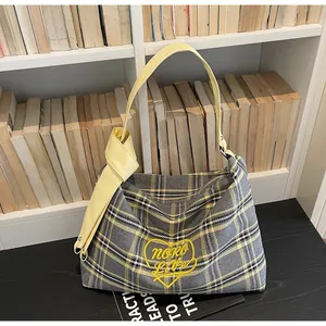 Detail of grey yellow plaid tote bag with heart embroidery and yellow knotted strap