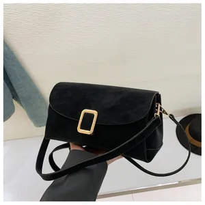 Detail of vintage black suede crossbody bag with elegant rectangular gold buckle clasp