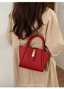 Detailansicht der roten Bucket Bag aus Leder mit Lychee-Narbung und Goldverschluss