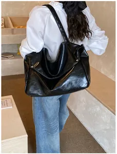 Detail einer schwarzen Kunstledertasche mit Vintage-Faltenstruktur und Metallnieten