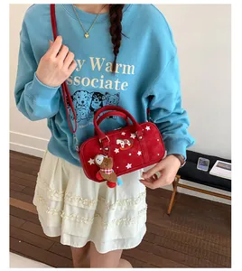 Detail of red Boston bag with star patterns, rocking horse embroidery, and bear charm
