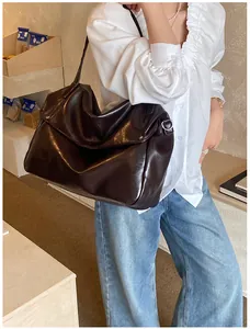 Detailansicht der tiefbraunen glänzenden Ledertasche mit minimalistischem Klappe