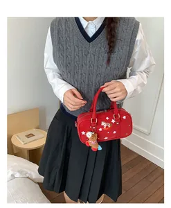 Cute red Boston handbag featuring white star patterns and a plush bear charm on model