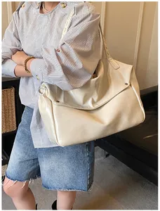 Detail der weichen cremefarbenen Ledertasche mit Überschlag und Metallbeschlägen