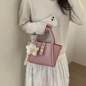 Rosa Eimer-Handtasche aus Leder mit Lychee-Muster, Stern-Anhänger und Goldschloss
