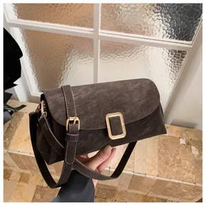 Macro detail of dark brown matte leather bag texture with gold rectangular buckle closure