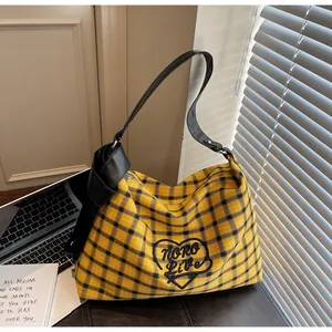 Detailed view of checkered tote bag featuring a large decorative black bow and leather strap