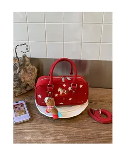 Detail of red Boston bag with pony embroidery, star patterns and plush charm accessory