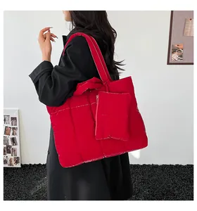 Détail du grand sac cabas matelassé rouge avec pochette assortie et texture brillante