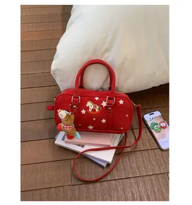 Detail of red Boston bag with horse embroidery, star prints and a plush charm