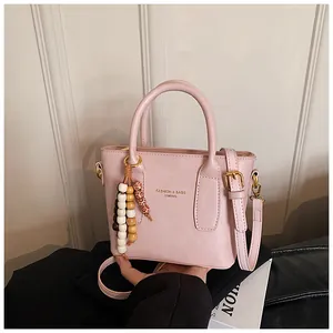 Detailaufnahme der rosa Tragetasche mit Markendruck und böhmischer Holzperlen-Quaste