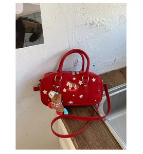 Macro shot of red Boston bag featuring star patterns and a vintage horse patch embroidery