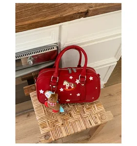 Detail of red Boston bag featuring star patterns and rocking horse embroidery with pony charm