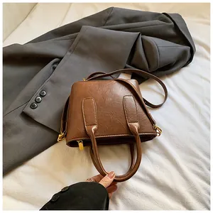 Detailansicht der braunen Vintage-Eimertasche mit Goldbeschlägen und Lederstruktur