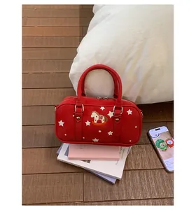 Detail of red suede Boston bag with horse embroidery and white stars in a cozy setting
